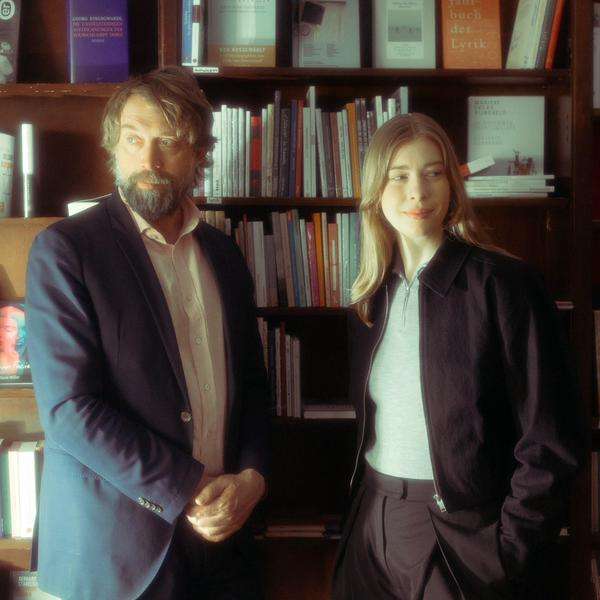 Ein Mann und eine Frau stehen vor einem Bücherregal.