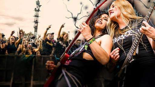 Zwei Frauen mit E-Gitarren in der Hand auf einem Metal-Festival.