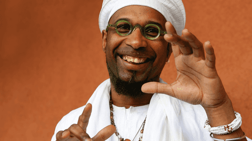 Omar Sosa blickt lachend in die Kamera.