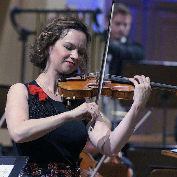 Violinistin Hilary Hahn, mittellange, braune Haare spielt zusammen mit einem Orchester.