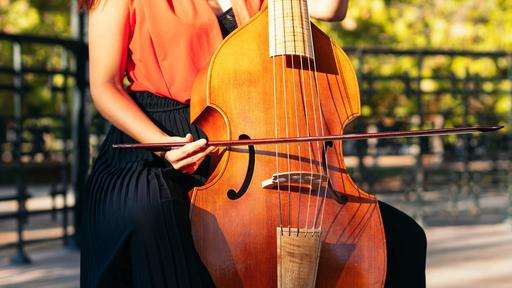 Eine Frau spielt Cello in einem Garten.