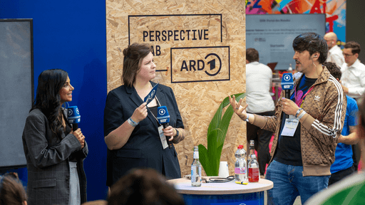 Drei Personen auf der re:publica 2024 an einem Stand.