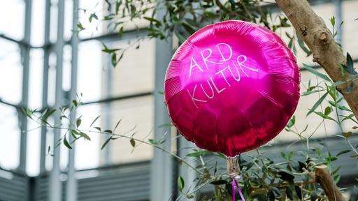 Ein pinker Luftballon mit der Aufschrift ARD Kultur schwebt in der Luft.