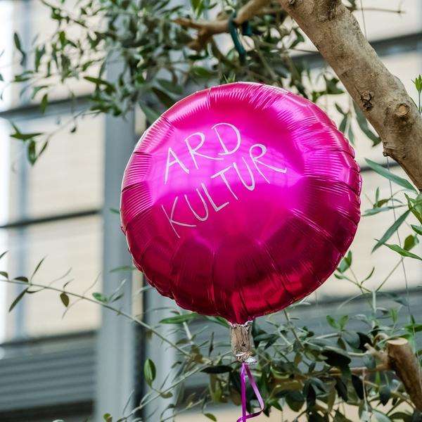 Ein pinker Luftballon mit der Aufschrift ARD Kultur schwebt in der Luft.