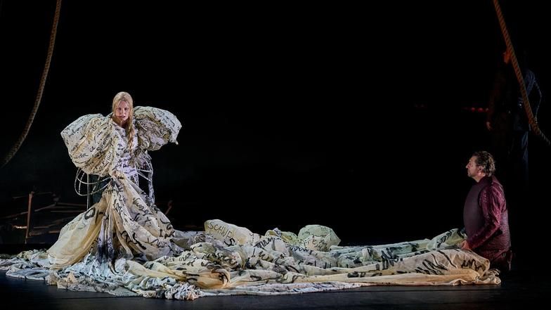 Bühnenszene aus der Oper von Richard Wagners "Tristan und Isolde". Im Bild: 1. Aufzug: Camilla Nylund als Isolde im pompösen mehrere Meter langen bauschigen Kleid und Andreas Schager als Tistan, knient vor Isolde.