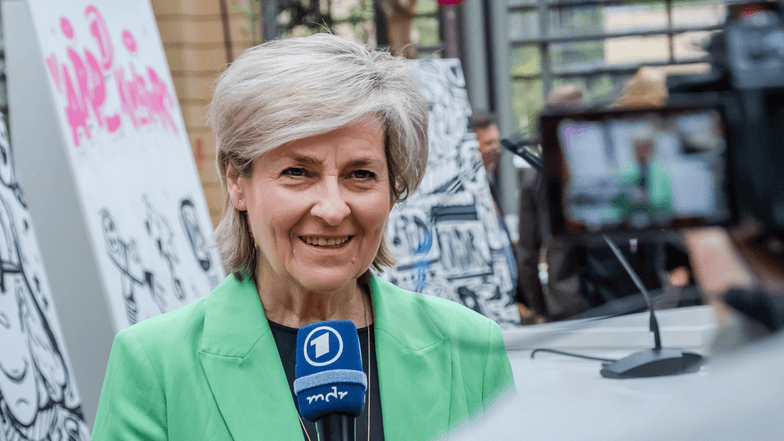 Intendantin Prof. Carola Wille mit einem Mikrofon in der Hand. Sie spricht in eine Kamera.