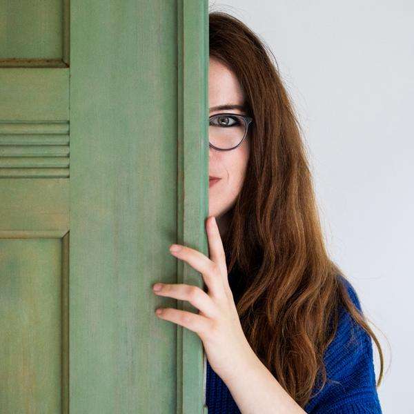Eine Frau schaut hinter eine Tür hervor. Davor die Aufschrift: "Deep Dialog".