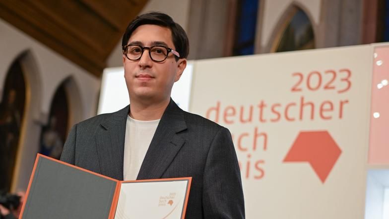 Der österreichische Autor Tonio Schachinger hält nach der Auszeichnung mit dem Deutschen Buchpreis 2023 für seinen Roman „Endzeitalter“ die Urkunde.