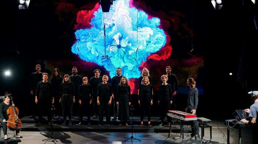 Der Chor d'aCHORd singt die Friedenshymne No! der Band Bukahara. Künstler Max Schweder lässt aus dem Gesang ein digitales Kunstwerk auf einer LED-Leinwand entstehen.